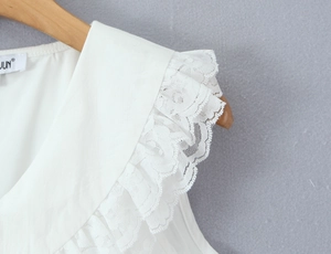 Détail d'une robe blanche avec dentelle multicouche et col Claudine classique