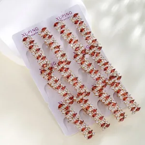 Detail of four gold hairpins with marquise red gems and white crystal pavé setting