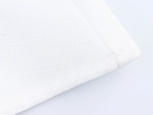 Close-up of white textile material showing textured fabric weaving and stitching detail