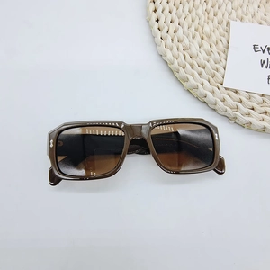 Detailansicht der braunen rechteckigen Retro-Sonnenbrille mit silbernen Nieten auf Weiß