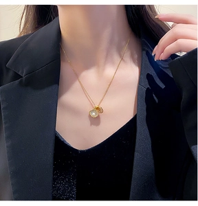 Detail of opening pearl shell pendant with zircon inlays on golden chain