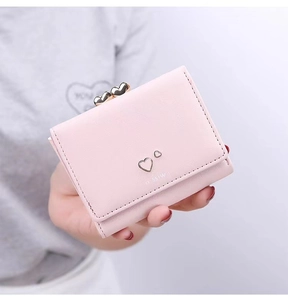Close-up of pink leather wallet with heart-shaped metal buckle and MISS engraving