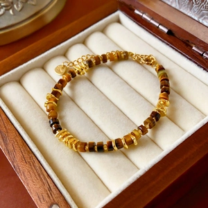 Detail of tiger eye stone beads and irregular gold metal links on a vintage bracelet
