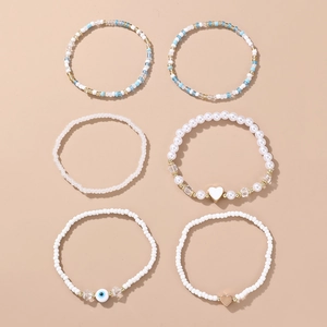 Detail view of 6-piece boho beaded bracelet set with evil eye and heart charms