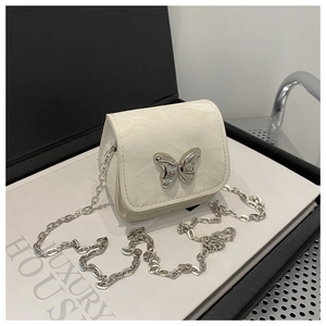 Close-up of white pleated crossbody bag featuring a polished silver butterfly clasp
