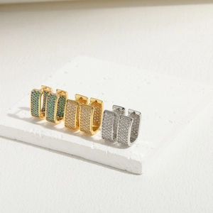 Macro view of square huggie earrings with gold and silver bases and colorful zircon inlays