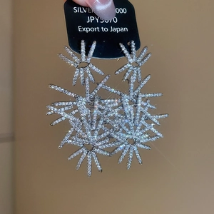 Macro shot of silver fireworks stud earrings with sparkling pavé zircons in starburst design