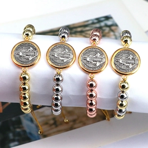 Detail of adjustable San Benedict religious medal bracelets in four metallic colors