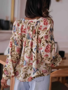Back view of a long-sleeved floral print blouse for women with lightweight pleated fabric