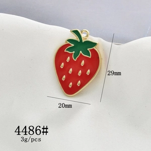 Detail view of strawberry charm pendant in red enamel with 29mm height and 20mm width