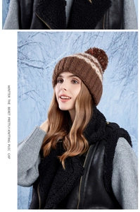 Close-up of brown knit winter hat with a pom-pom and thick wave texture in the snow