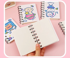 Close-up of A7 pocket notebook showing blank inner pages and astronaut cover graphics