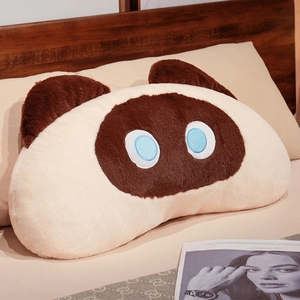 Detailed close-up of a Siamese cat plush pillow case with blue eyes on a bed