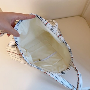 Vue intérieure du sac cabas matelassé avec poche zippée et motif floral de cerises rouges