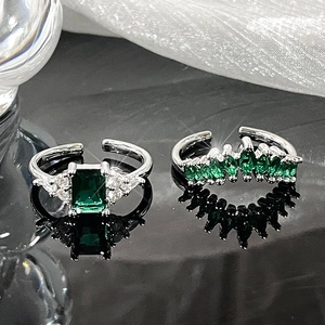 Detail of emerald cut green zircon and marquise stones on silver open rings