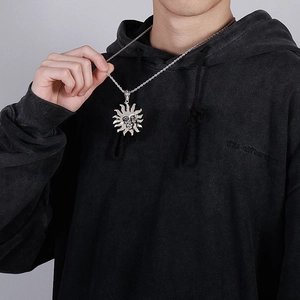 Detail of silver sun face pendant with twist chain worn on a black sweatshirt