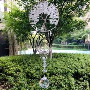 Macro shot of silver Tree of Life crystal suncatcher with butterfly and prism ball