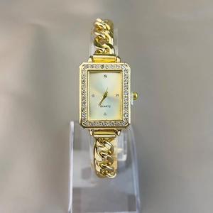 Detail of gold rectangular women's watch featuring a crystal bezel and quartz movement