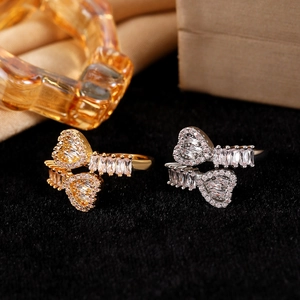 Macro shot of gold and silver heart rings with paved cubic zirconia on black velvet
