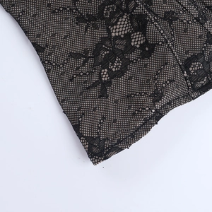 Close-up of black floral lace fabric with intricate mesh texture and delicate patterns