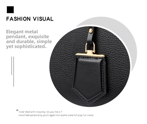 Close-up of black litchi grain leather texture and gold geometric hardware pendant charm