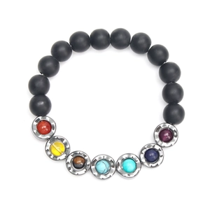 Detail of matte black beads and chakra stones set in metal on a wave yoga bracelet