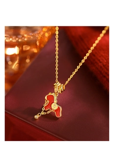 Detail view of the gold horse necklace with red enamel and lucky coin charms for women