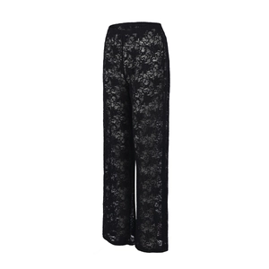 Detailed view of floral lace pattern and sheer texture on these black wide-leg trousers