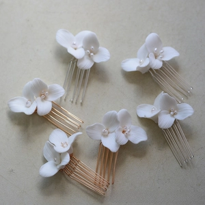 Detail of handmade white ceramic flower hair combs with freshwater pearls for brides