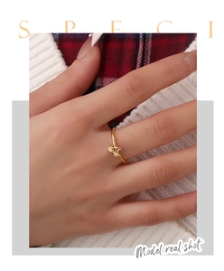Detailed close-up of a gold-plated coconut tree and moon ring on a finger