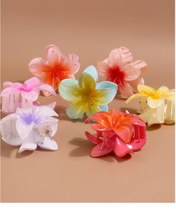 Detail view of colorful gradient plumeria flower hair claws in high-quality resin