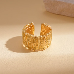 Macro view of golden adjustable open ring with dense granular texture and metallic finish