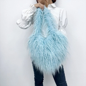 Close-up of fluffy light blue faux fur texture on a large heart-shaped shoulder bag