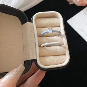 Detail of light blue enamel ring with rectangular zircon and white band in a jewelry box
