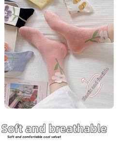 Dettaglio calze in cotone rosa a metà tubo con motivo floreale bianco ed elastico