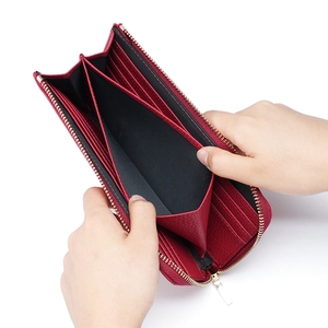 Women's long RFID leather wallet in dark red with pebble grain and zip-around closure