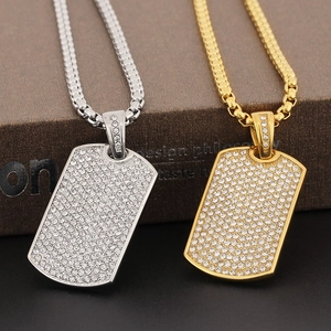 Detail of hip hop dog tag pendants in gold and silver finish with micro paved rhinestones
