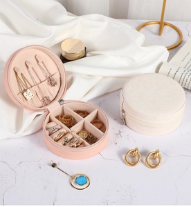 Detail view of pink and beige round leather jewelry box with interior storage sections