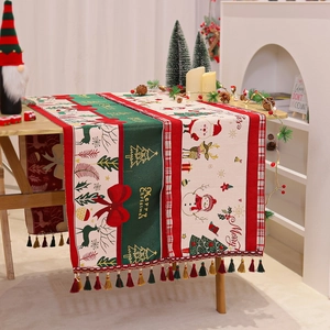 Detailed view of chenille Christmas table runner with festive prints and colorful tassels