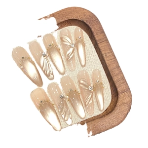 Faux ongles perle champagne avec ailes 3D et strass en forme d'amande