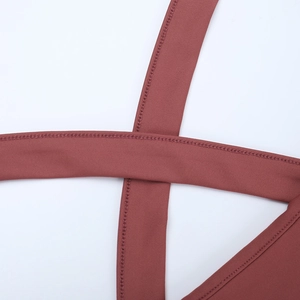 Détail des bretelles croisées au dos d'une robe longue dos nu de couleur rouge foncé