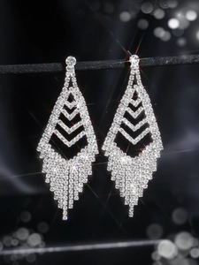 Close-up of sparkling long tassel earrings with rhinestones and starburst lighting effect