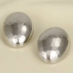 Macro shot of silver 304 stainless steel stud earrings with hammered oval texture detail