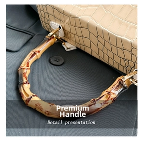 Close-up of cream crocodile pattern leather handbag featuring a natural bamboo handle