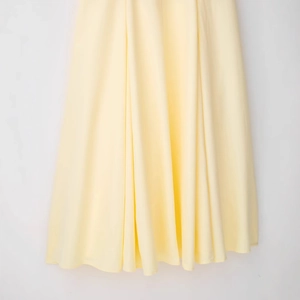 Abito a camicia in chiffon giallo pallido con colletto a rever e gonna fluida in studio