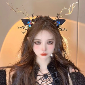 Detail showing red velvet roses and dark reindeer antlers on a fantasy hair clip