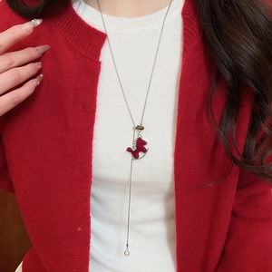 Détail d'un pendentif poney rouge avec perle sur un collier long en forme de Y argenté
