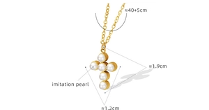 Detailed view of a gold cross pendant with six imitation pearls on a white background