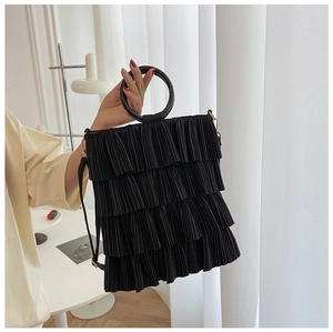 Detail of black tiered ruffle shoulder bag with multiple pleated layers and round handle