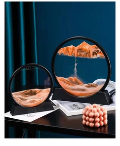 Detail of round orange liquid sand art landscape in black frame on a dark office desk